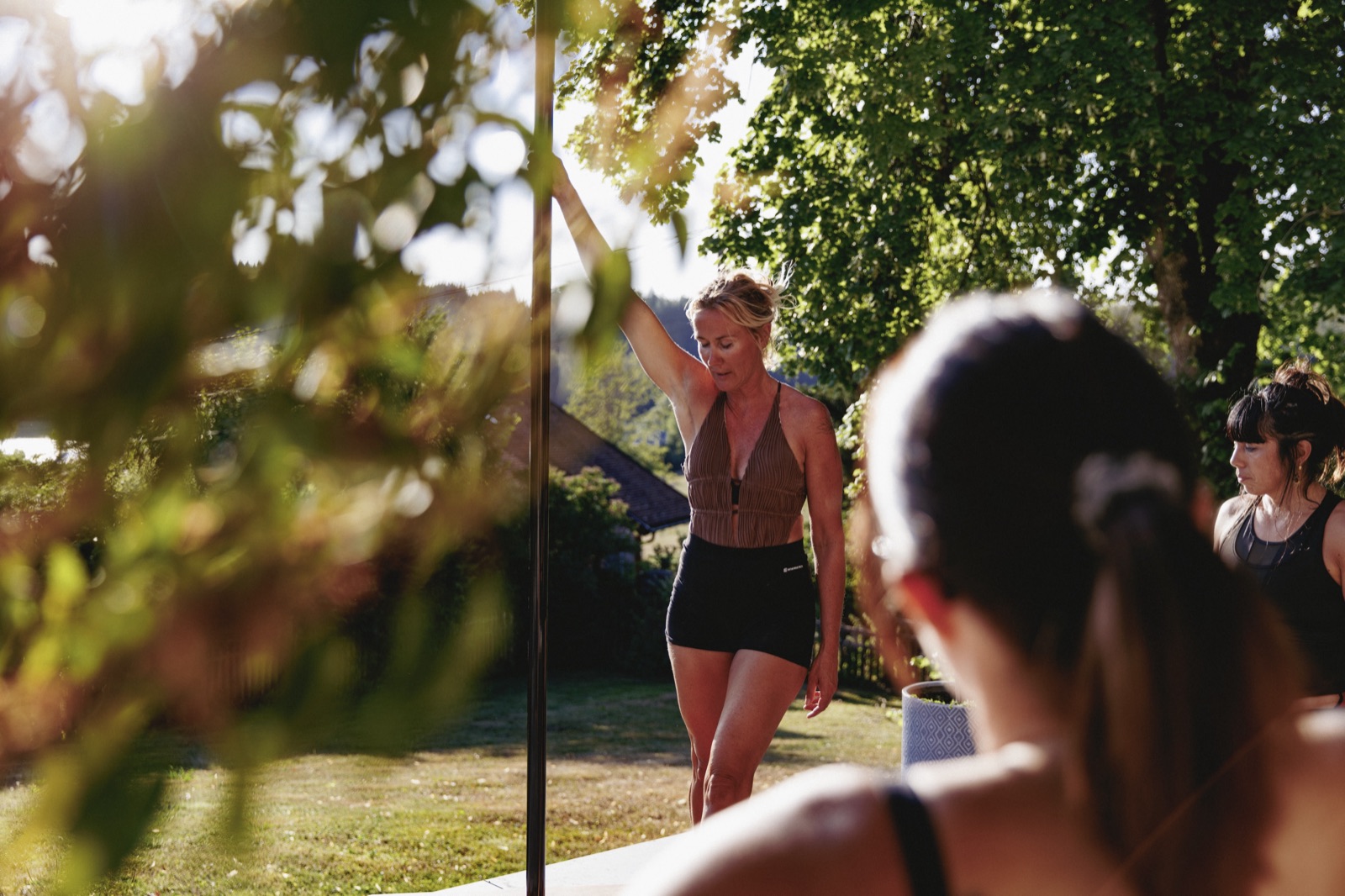 Cours de pole dance dans le jardin, en lumière naturelle de fin de journée, près du lac Saint-Point